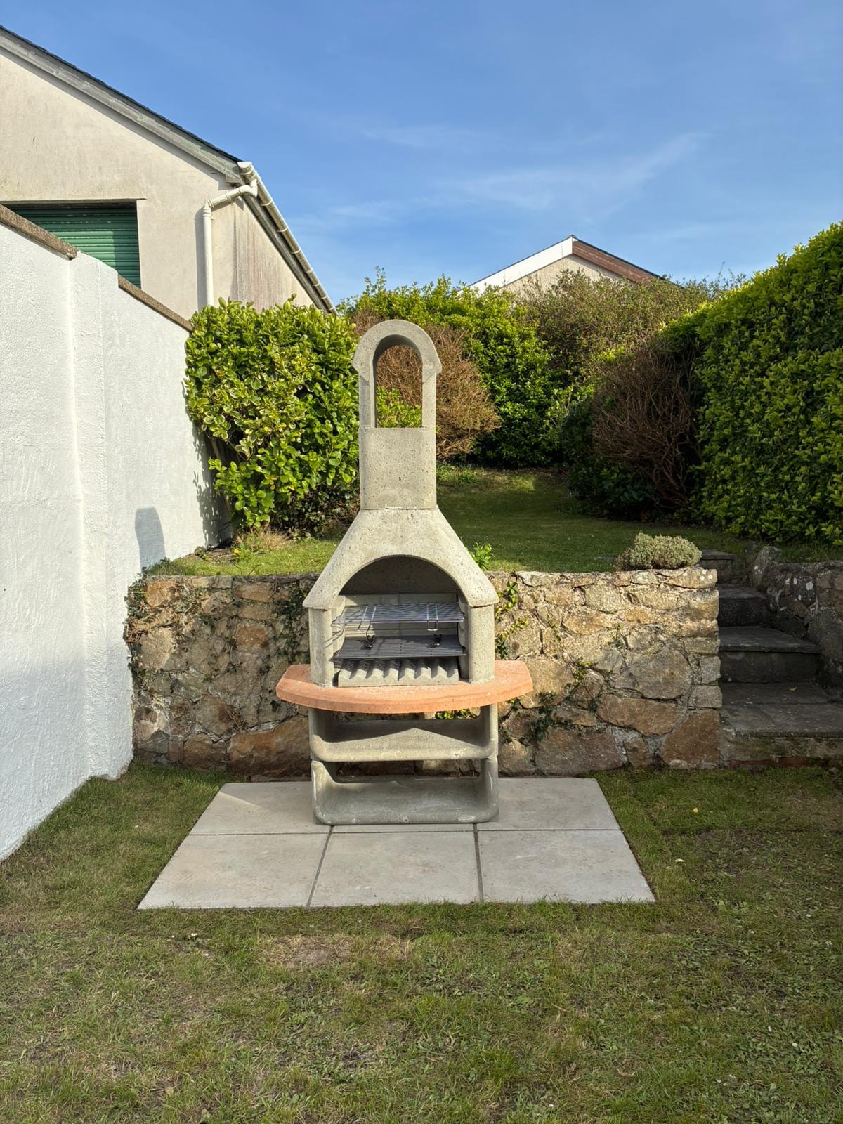 Outdoor stone chiminea on concrete slab with pavers