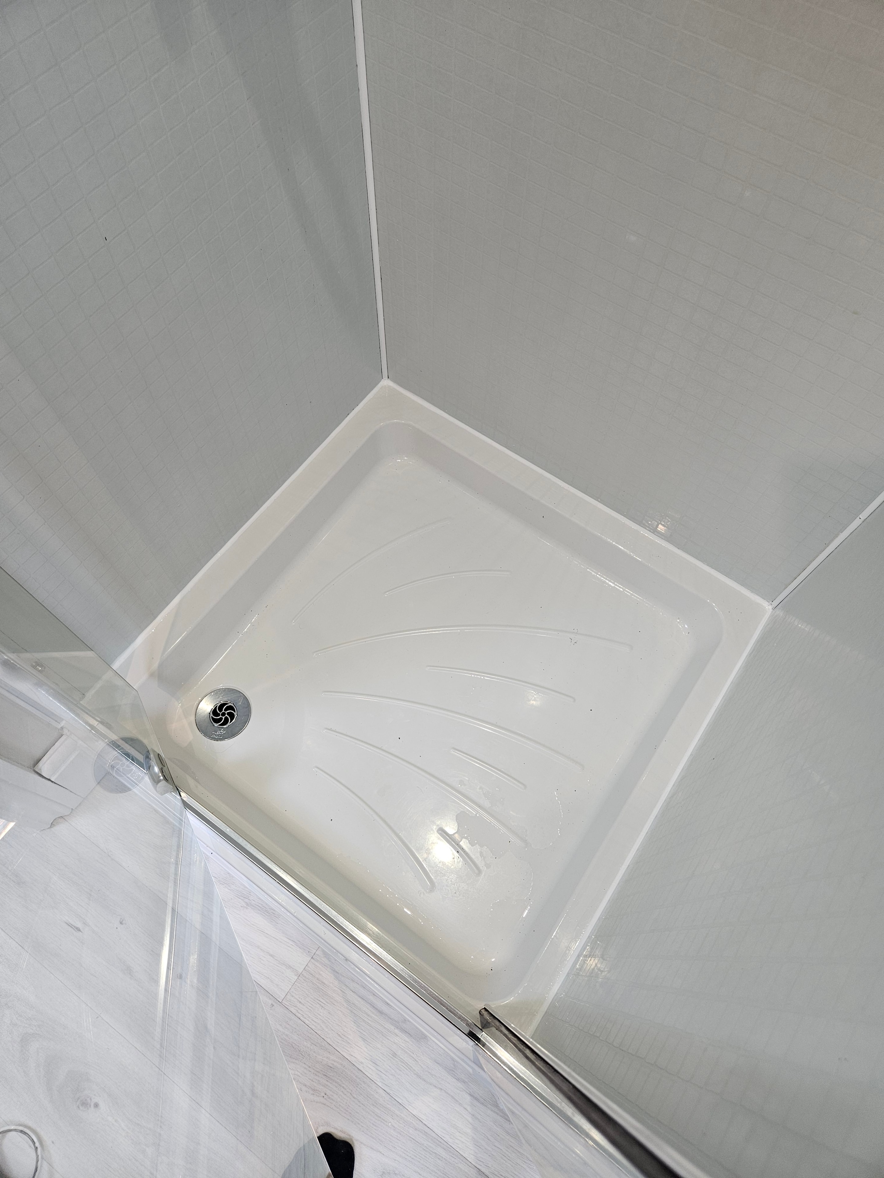 Shower tray after deep cleaning and fresh silicone resealing in Anglesey